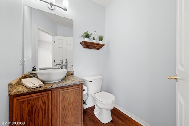 bathroom featuring wood-type flooring, toilet, and vanity