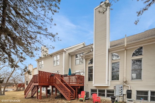 rear view of property featuring a wooden deck and central AC