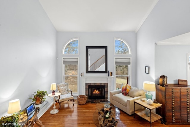 living room featuring hardwood / wood-style flooring, plenty of natural light, a fireplace, and crown molding