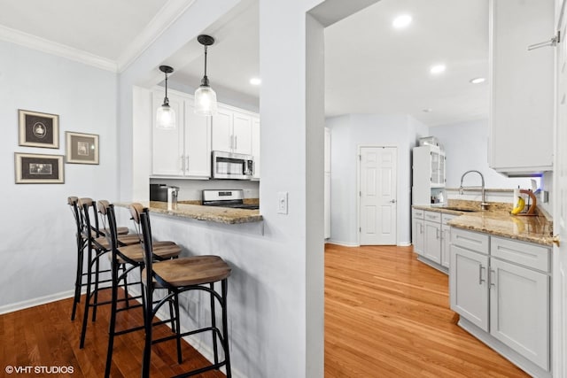 kitchen featuring stainless steel appliances, light hardwood / wood-style floors, sink, and white cabinets