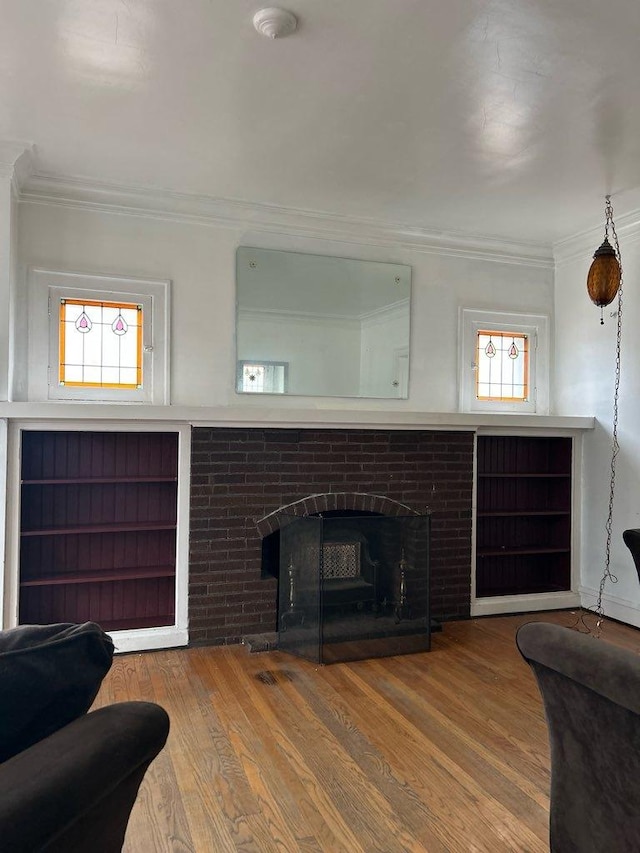 living room with hardwood / wood-style flooring, ornamental molding, and a fireplace