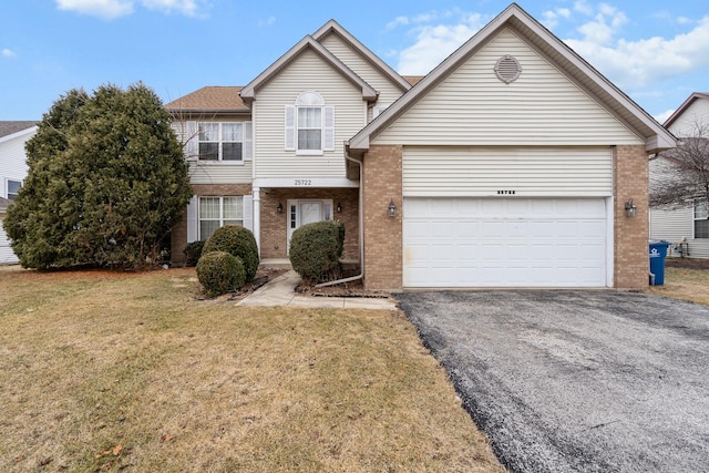 view of property featuring a garage and a front lawn