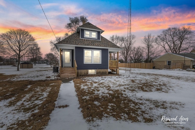 bungalow featuring a shed and cooling unit