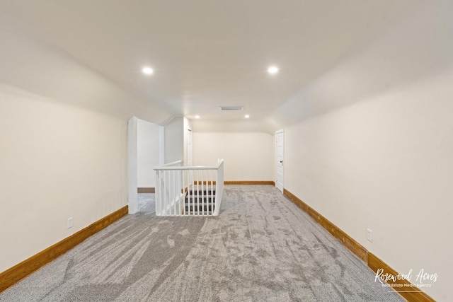 carpeted empty room featuring lofted ceiling