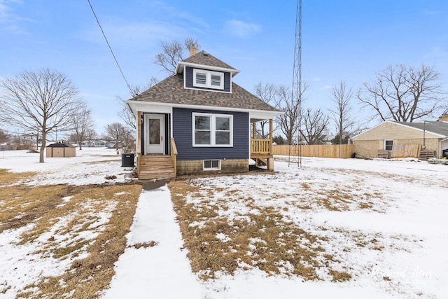 bungalow with central air condition unit and a storage shed