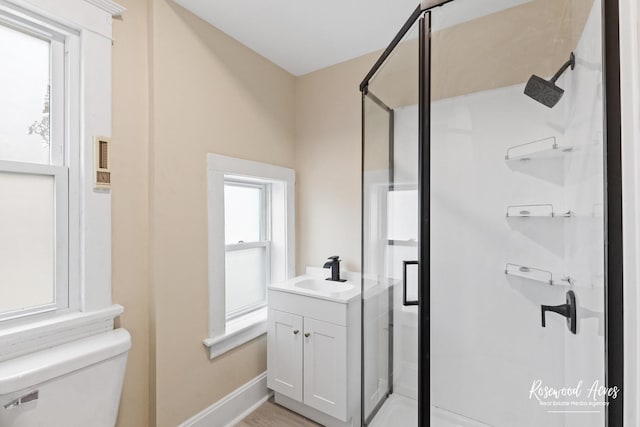 bathroom featuring toilet, vanity, and an enclosed shower