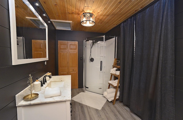 bathroom featuring hardwood / wood-style flooring, a shower, vanity, and wood ceiling