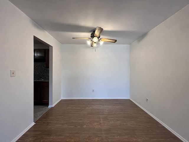 spare room with dark hardwood / wood-style flooring and ceiling fan