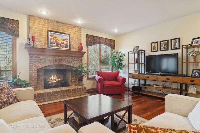 living room featuring a brick fireplace and wood-type flooring