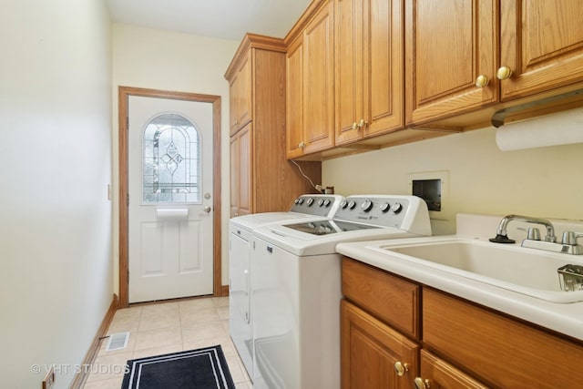 laundry room featuring sink, washer and clothes dryer, cabinets, and light tile patterned flooring