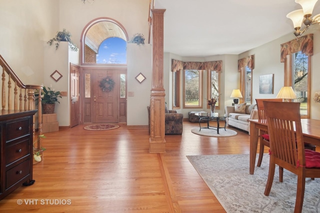 foyer entrance with decorative columns and light hardwood / wood-style flooring