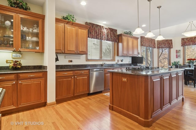 kitchen featuring a kitchen island, appliances with stainless steel finishes, pendant lighting, and light hardwood / wood-style floors