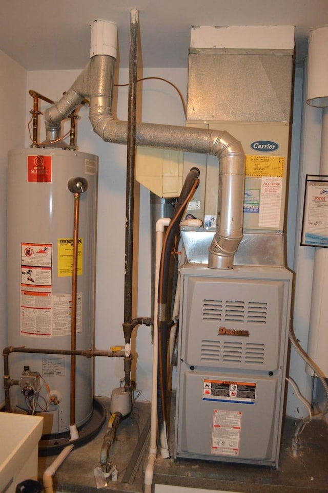utility room with heating unit and gas water heater