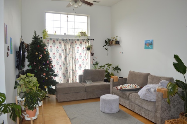 living room featuring visible vents, a ceiling fan, and wood finished floors