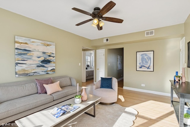 living area featuring visible vents, ceiling fan, light wood-type flooring, and baseboards