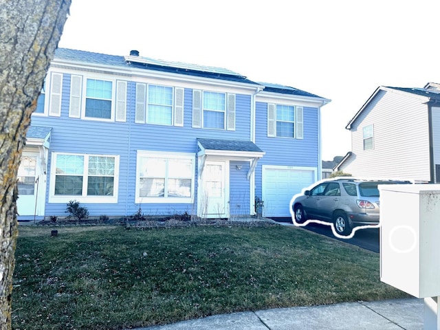 view of front facade with a garage, a front yard, and driveway