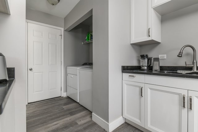 washroom featuring dark hardwood / wood-style flooring, washer and clothes dryer, and sink