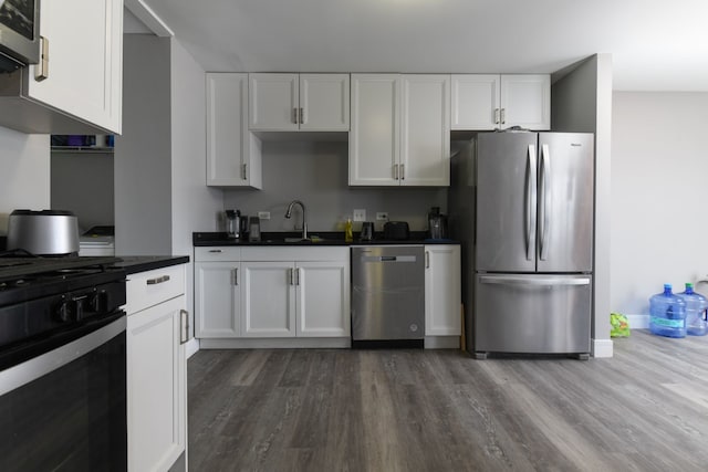 kitchen featuring white cabinetry, sink, hardwood / wood-style flooring, and appliances with stainless steel finishes