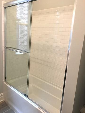 bathroom with shower / bath combination with glass door