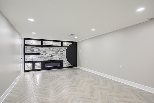 unfurnished living room featuring a large fireplace and light parquet floors