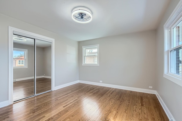 unfurnished bedroom with wood-type flooring and a closet