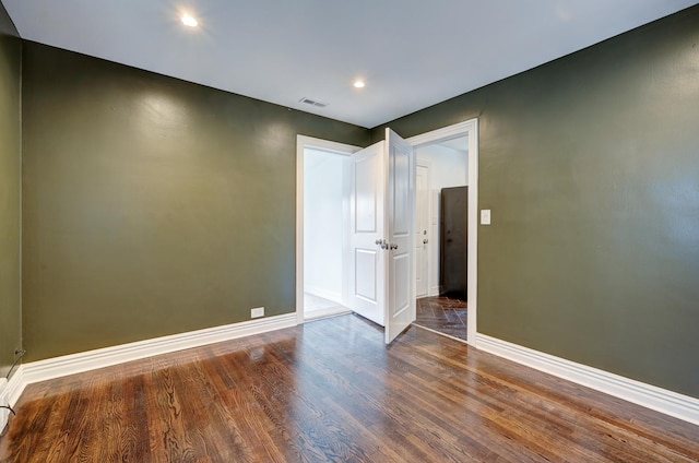 empty room with dark hardwood / wood-style flooring