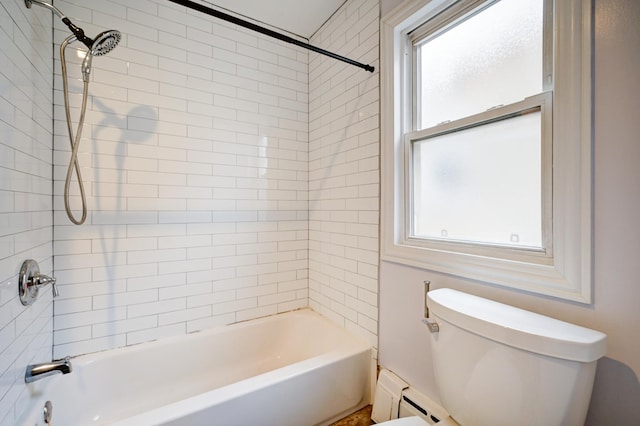 bathroom featuring baseboard heating, tiled shower / bath, a healthy amount of sunlight, and toilet