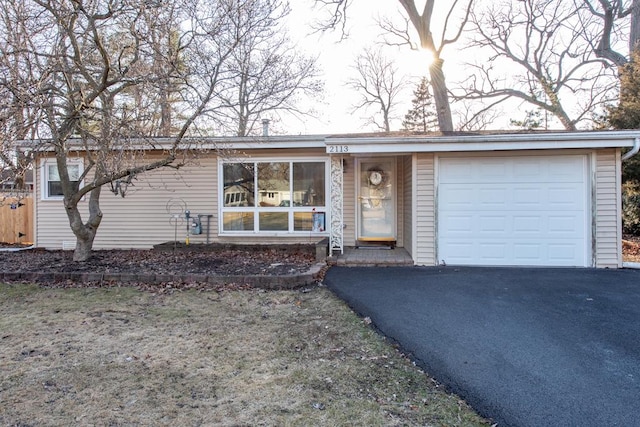 ranch-style home with aphalt driveway and an attached garage