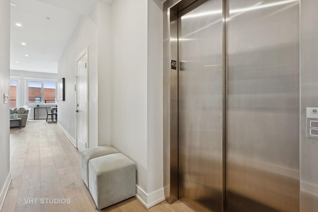 hallway featuring elevator and light wood-type flooring