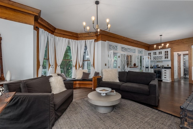 living room with indoor bar, dark hardwood / wood-style floors, beverage cooler, and an inviting chandelier