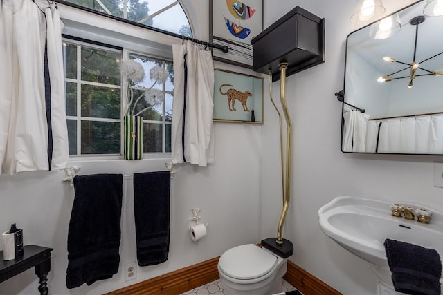 bathroom featuring sink, a chandelier, and toilet