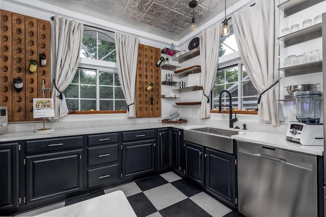 kitchen featuring stainless steel dishwasher, sink, and hanging light fixtures