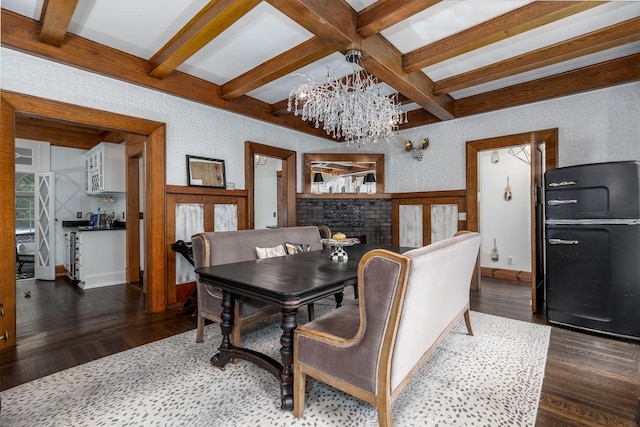 dining area featuring a brick fireplace, beam ceiling, dark hardwood / wood-style floors, and french doors