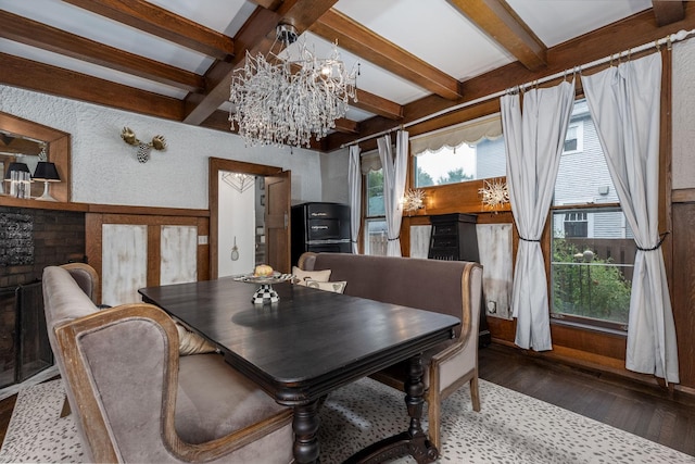 dining space with hardwood / wood-style flooring, a notable chandelier, and beam ceiling