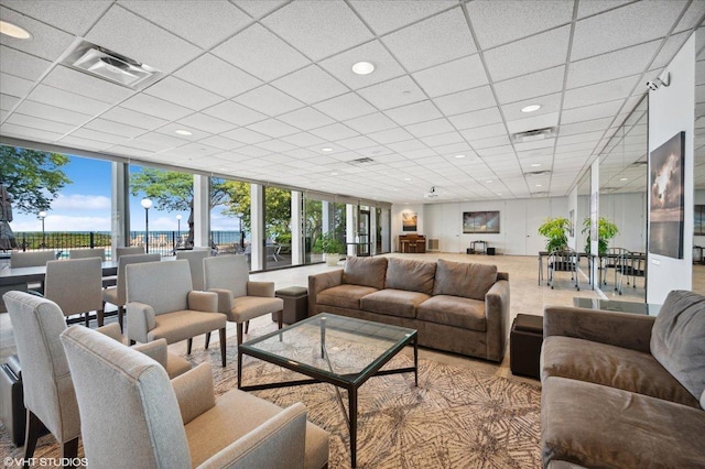 living room with floor to ceiling windows, visible vents, and a wealth of natural light