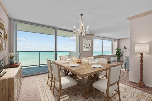 dining space featuring a water view, a chandelier, and a wall of windows