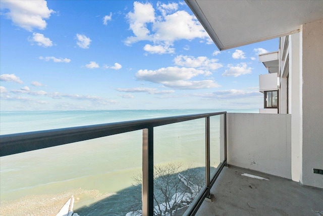 balcony featuring a water view and a beach view