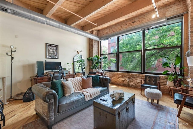 living room featuring wood-type flooring, wooden ceiling, beamed ceiling, and brick wall