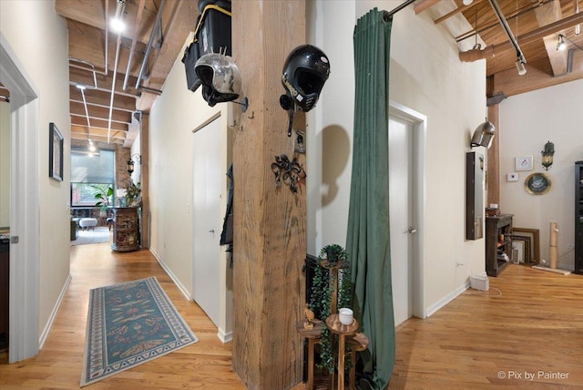 hall featuring light hardwood / wood-style floors and a high ceiling