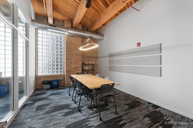 dining area featuring beamed ceiling, a high ceiling, a healthy amount of sunlight, and wooden ceiling