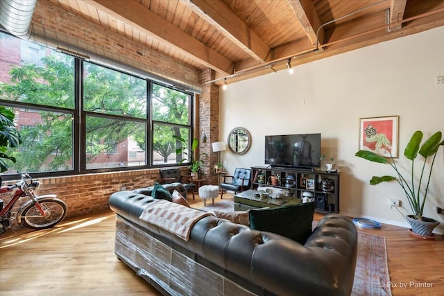 living room with wood ceiling, beam ceiling, light hardwood / wood-style flooring, and brick wall