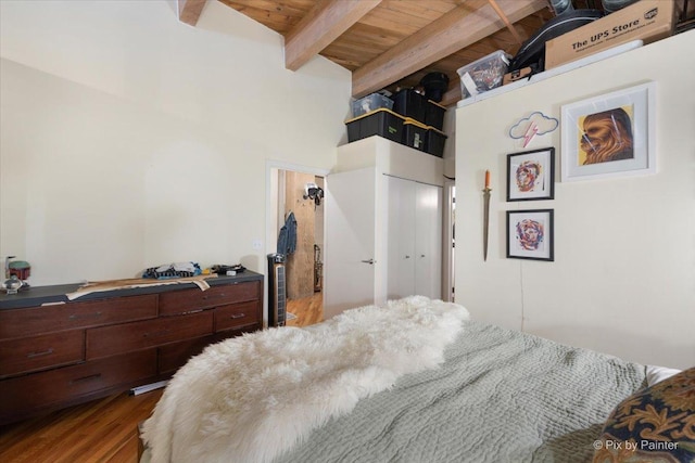 bedroom with wood ceiling, hardwood / wood-style flooring, beam ceiling, a towering ceiling, and a closet