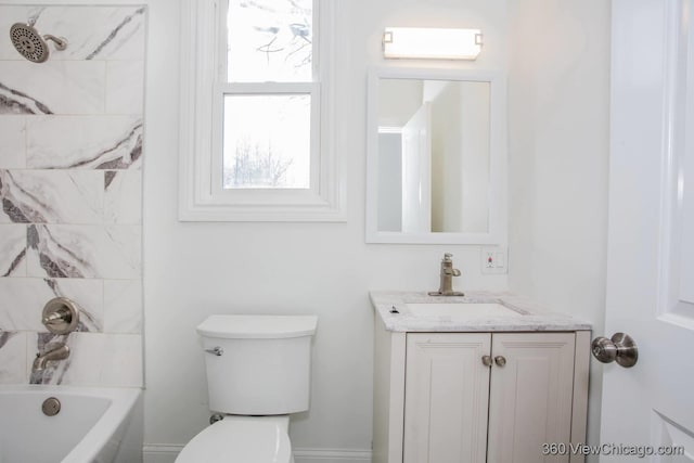 full bathroom featuring vanity, tiled shower / bath, and toilet