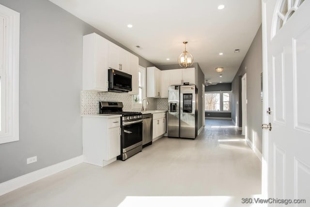 kitchen featuring pendant lighting, sink, appliances with stainless steel finishes, tasteful backsplash, and white cabinets