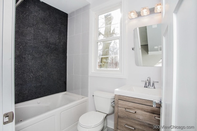 full bathroom featuring vanity, tiled shower / bath combo, and toilet