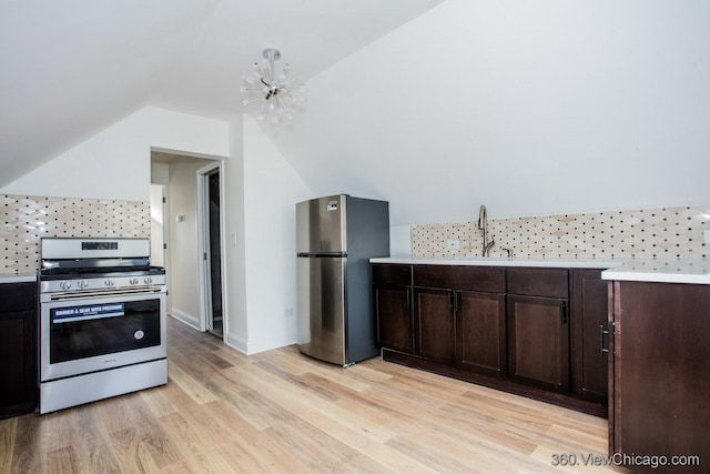 kitchen with lofted ceiling, backsplash, stainless steel appliances, dark brown cabinets, and light hardwood / wood-style flooring