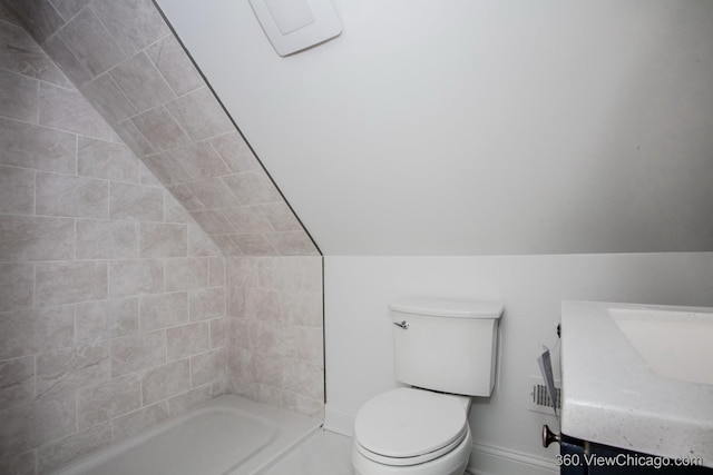 bathroom with vanity, toilet, and vaulted ceiling