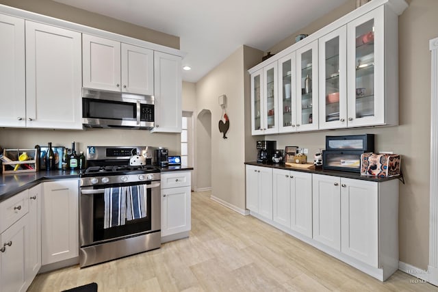 kitchen with white cabinetry, stainless steel appliances, and light wood-type flooring