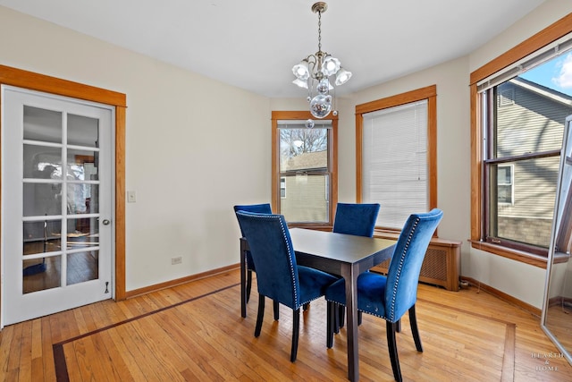 dining area with a chandelier and light hardwood / wood-style flooring