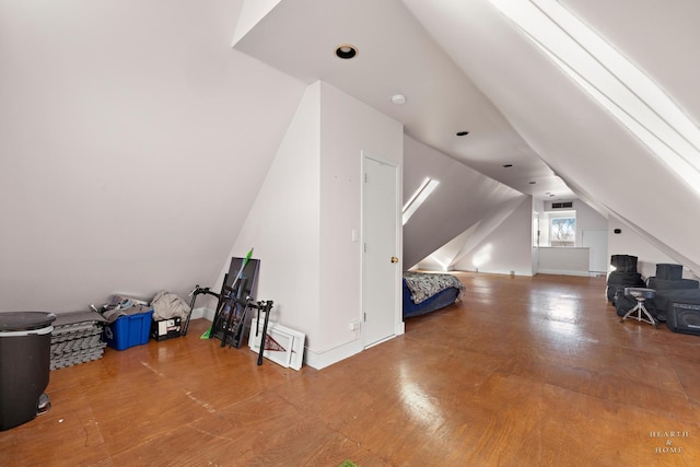 additional living space with hardwood / wood-style flooring and lofted ceiling